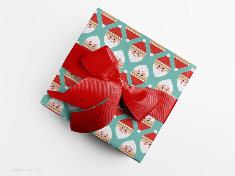 Christmas gift wrapped in modern, geometric Santa wrapping paper with red ribbon by Gigglemugg