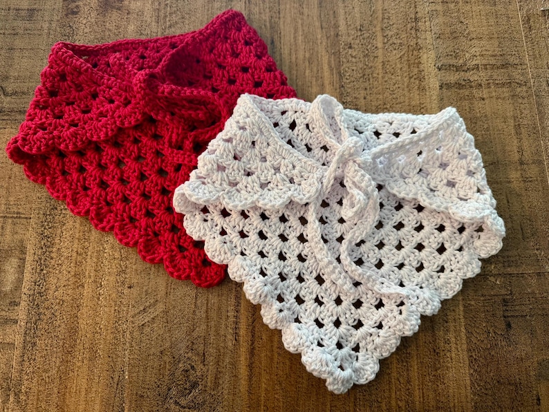 May include: Two handmade crochet shawls. One is a vibrant red, the other is white. Both have a scalloped edge and a tie closure. The open weave design is visible. These shawls are perfect for adding a touch of handmade charm to any outfit.