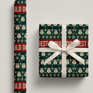 May include: A roll of wrapping paper and a wrapped gift box. Both feature a green background with a repeating pattern of snowmen and snowflakes. The paper has the text "ULD DO" in red. The gift box has a white ribbon and the text "BEST ULD DO BEST".