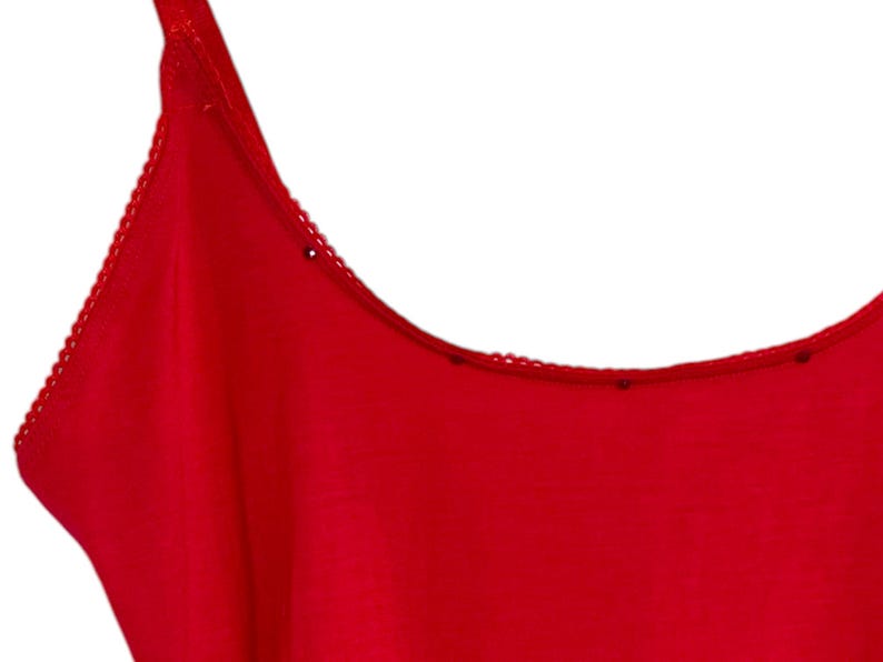 May include: A red sleeveless top with a scalloped neckline.