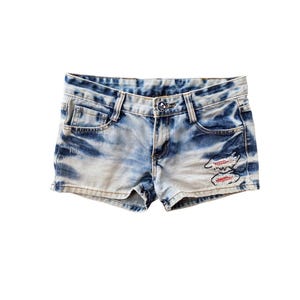 May include: Light blue denim shorts with a tie-dye pattern and red embroidered details.