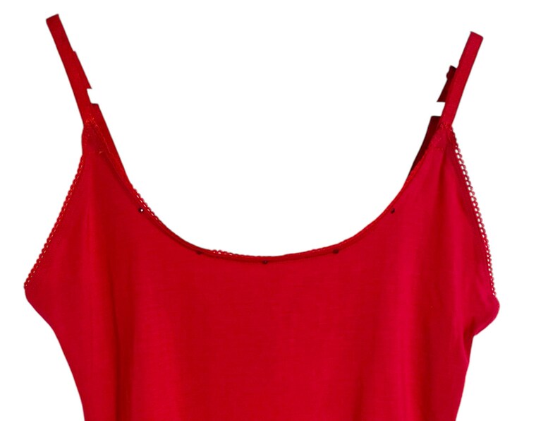 May include: A red tank top with thin straps and a scalloped trim around the neckline.