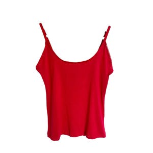 May include: A red sleeveless tank top with thin straps.
