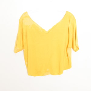 May include: A yellow short-sleeved v-neck t-shirt with a slightly cropped hem.