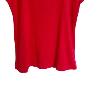 May include: A plain, bright red t-shirt with short sleeves and a scoop neck.