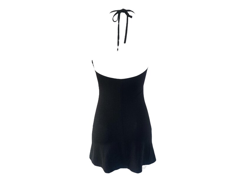 May include: A black halter dress with a flared hem. The dress features a halter neckline with tie straps. The back of the dress is visible, showcasing the open design. The dress is made of a smooth, solid fabric.