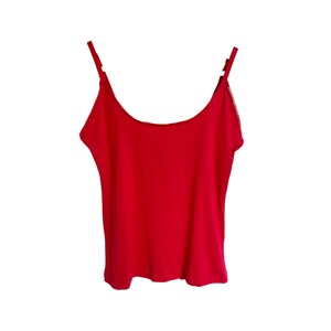 May include: A red sleeveless tank top with thin straps.