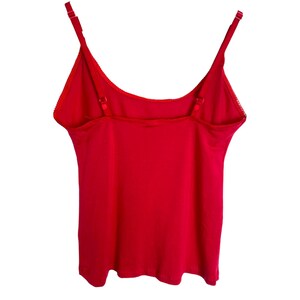 May include: A red sleeveless tank top with adjustable straps.