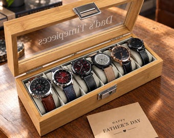 May include: A rectangular bamboo watch box with a glass lid featuring the text "Dad's Timepieces" and a metal latch. Inside, six wristwatches with various leather and metal straps are displayed on cushions. A card reads "HAPPY FATHER'S DAY".
