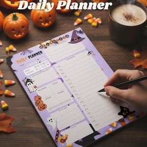 Könnte beinhalten: Ein Halloween-Tagesplaner mit lila Hintergrund, der eine Hexenhut-, Geister- und Kürbis-Illustrationen zeigt. Der Planer enthält Abschnitte für die Planung, Notizen und eine To-Do-Liste. Süßigkeiten und Kürbisdekorationen umgeben den Planer.