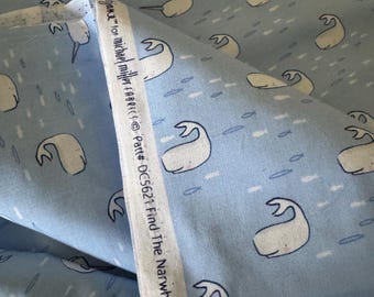 May include: Pale blue fabric featuring a repeating design of white narwhals and small fish. The fabric is labelled "Find The Narwhal" and is from Michael Miller Fabrics. The fabric is folded over, revealing the pattern.