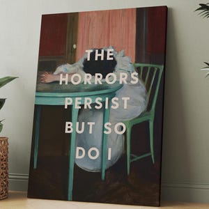 Peut inclure: Impression sur toile encadrée avec l'inscription "THE HORRORS PERSIST BUT SO DO I". L'œuvre représente une personne assise à une table. La peinture a une esthétique vintage, avec une table et une chaise turquoise.