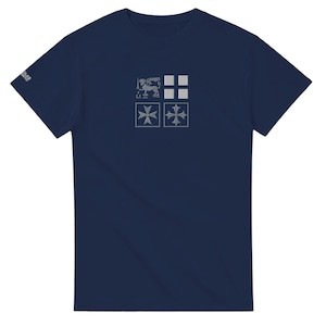 Pode incluir: Camiseta azul marinho com um design de quatro quadrados com um leão, quadrados e cruzes. A camiseta tem mangas curtas e gola redonda. O texto "OLAS MITO" é impresso na manga esquerda.