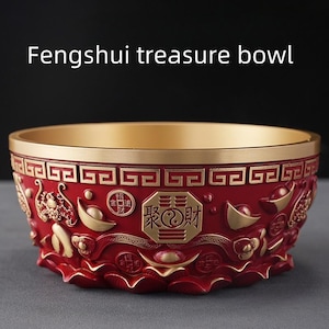 Könnte beinhalten: Rote und goldene Fengshui-Schatzschale mit aufwendigen Reliefschnitzereien. Die Schale hat goldene Akzente am Rand und im Inneren, mit detaillierten Reliefmustern und chinesischen Schriftzeichen. Der Text "Fengshui treasure bowl" wird über der Schale angezeigt.