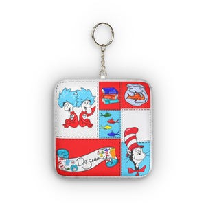 Può includere: Portachiavi quadrato con un design patchwork con illustrazioni dai libri del Dr. Seuss. Il design include il Gatto col cappello, Thing 1 e Thing 2, un pesce rosso in una boccia e pesci colorati. Il portachiavi ha un anello in metallo argentato.