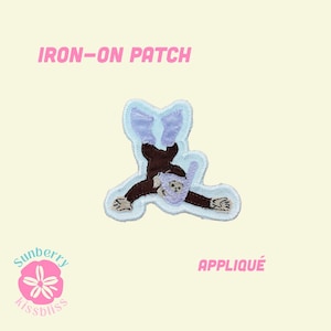 May include: An iron-on patch featuring an embroidered brown monkey wearing a light purple snorkel mask and matching flippers. The design is outlined in light blue thread against a pale yellow background with the text IRON-ON PATCH and APPLIQUÉ.