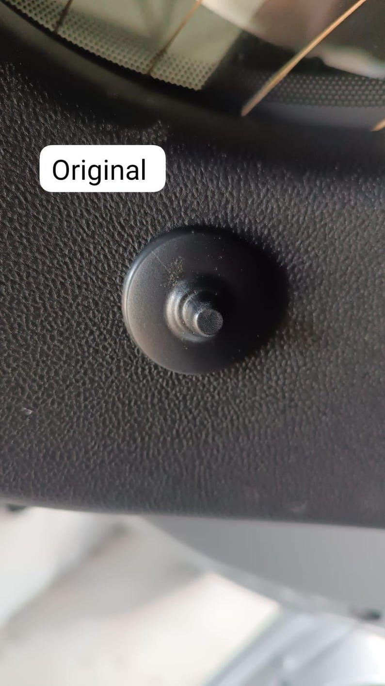 May include: Close-up of a black plastic fastener with a circular head and a cylindrical post. The fastener is set against a textured, dark gray surface. The word "Original" is in a white rectangle.