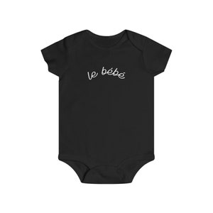 May include: Black baby bodysuit with short sleeves. The words "le b&eacute;b&eacute;" are written in white script across the chest. The bodysuit is made of soft fabric and has a snap closure at the bottom.