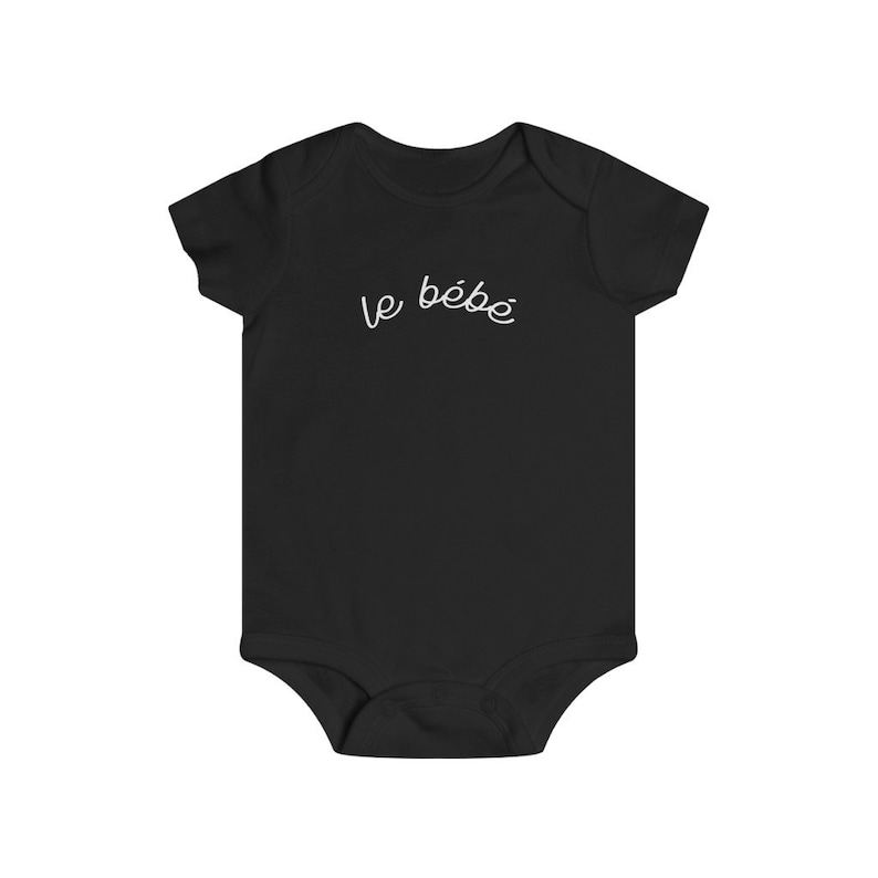 May include: Black baby bodysuit with short sleeves. The words "le b&eacute;b&eacute;" are written in white script across the chest. The bodysuit is made of soft fabric and has a snap closure at the bottom.