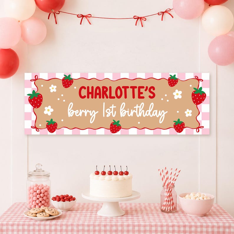 May include: A rectangular party banner featuring a pink and white checkered border, a tan center panel, and red strawberries with white flowers. The text reads "Charlotte's berry 1st birthday" in red and white script and block lettering.