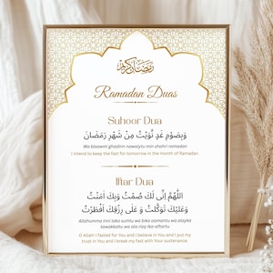 May include: A framed print with gold accents features "Ramadan Duas" in elegant script. The print includes Arabic text and English translations of prayers for Suhoor and Iftar, suitable for Islamic home decor.