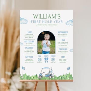 May include: A personalized poster with the text "WILLIAM'S FIRST HOLE YEAR" and a photo of a baby. The poster includes the baby's favorite things, nicknames, and measurements. The design features a golf theme with a golf cart illustration and blue accents.