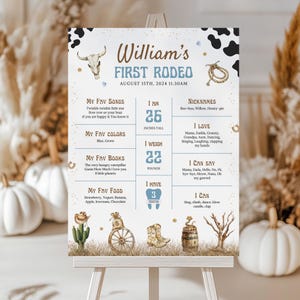 May include: A personalized sign for a first rodeo, featuring the text "William's FIRST RODEO" and event details. The sign includes a bull skull, rope, and other rodeo-themed illustrations. It lists the child's favorite songs, colors, books, and food. The child is 26 inches tall and weighs 22 pounds.