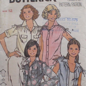 May include: A Butterick 6101 sewing pattern envelope featuring illustrations of four variations of a collared shirt with tie-shoulder details. The designs include a solid cream shirt, a solid pink shirt, a floral print shirt, and a sleeveless vest style.