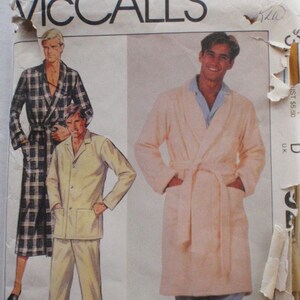 Op de afbeelding: Een witte keramische mok met een zwarte handgreep en de tekst "But First, Coffee" in een vetgedrukte, zwarte letter. De mok staat tegen een neutrale achtergrond, wat het eenvoudige ontwerp benadrukt.