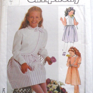 May include: Simplicity sewing pattern for girls' dresses. The pattern features illustrations of three different dress designs, including a white top with a striped skirt, a peach dress, and a striped dress. The pattern number is 7296.