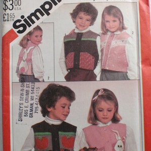 May include: Simplicity sewing pattern for children's vests. The pattern features multiple vest designs with various appliqués, including a bunny and hearts. The pattern includes the text "marjorie puckett" and "SHIRLEY'S SEW-N-SHOP".