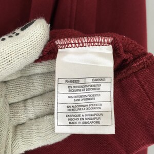 Może przedstawiać: Biały ceramiczny kubek z kolorowym kwiatowym wzorem. Kubek posiada uchwyt i błyszczące wykończenie. Kwiaty są w odcieniach r&oacute;żu, fioletu i ż&oacute;łci. Kubek jest prawdopodobnie przeznaczony do gorących napoj&oacute;w.