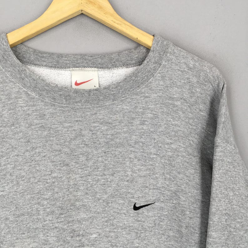 May include: A white ceramic mug with a black handle and the text "But First, Coffee" in a black, handwritten-style font. The mug is on a white surface.