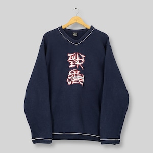 May include: Navy blue V-neck sweatshirt with white trim and a stylized red and white graphic on the front. The sweatshirt is hanging on a wooden hanger against a light gray background. The graphic appears to be Asian-inspired.