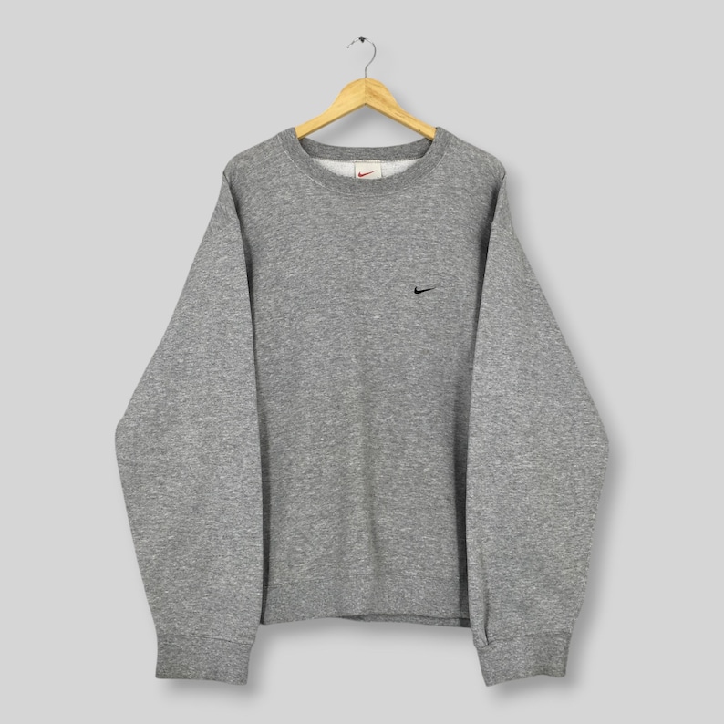 May include: A set of three ceramic mugs with a speckled, matte finish. The mugs are in shades of cream, light gray, and dark gray. Each mug has a simple, minimalist design, perfect for coffee or tea.