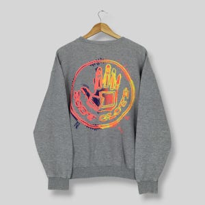 May include: A gray sweatshirt with a circular graphic on the back. The graphic features a hand inside a circle with the words "BODY GLOVE" in orange. The hand and circle have orange, yellow, and blue accents.