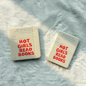 May include: Two rectangular cream-colored notebooks featuring a vintage library checkout card design printed in black and red. The text reads "KEEP THIS BOOK CLEAN DO NOT TURN DOWN THE PAGES" and "HOT GIRLS READ BOOKS" in bold red capital letters.