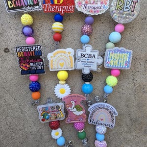 Puede incluir: Siete portatarjetas con cuentas de silicona y purpurina de colores y varios adornos acrílicos. El texto incluye Registered Behavior Technician, ABA Therapist, BCBA Board Certified Behavior Analyst, Behavior Analyst y frases como Off to Regulate Emotions.