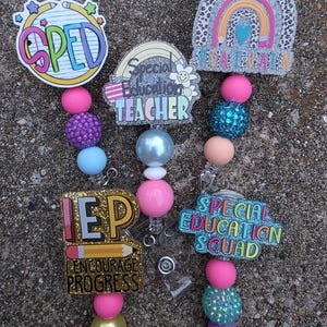 Può includere: Una collezione di colorati porta badge con le scritte "SPED", "Special Education Teacher", "IEP Encourage Progress" e "Special Education Squad". Ogni porta badge presenta perline decorative in vari colori come rosa, viola e turchese.