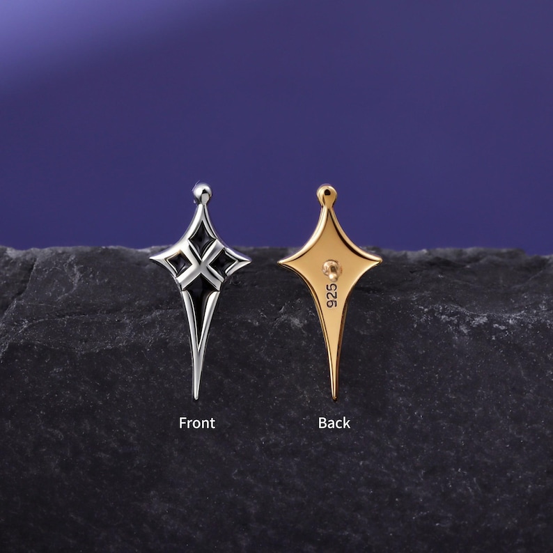 May include: A four-pointed star-shaped earring shown from two angles. The front view is silver-toned with black enamel detailing. The back view is gold-toned with a post and the text 925 stamped on the surface. The word Front is below the silver earring and the word Back is below the gold earring.