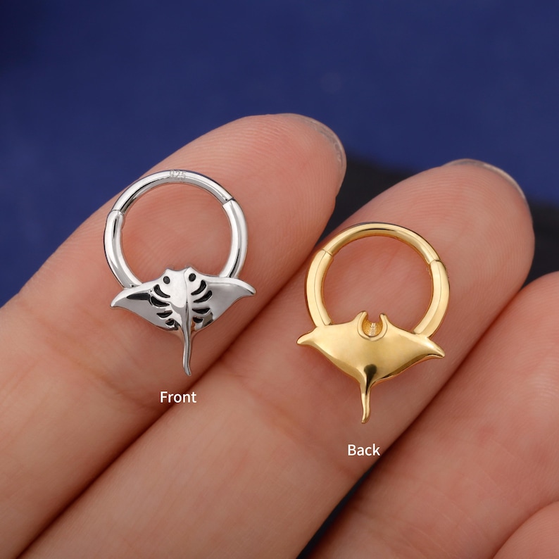 May include: Two hoop earrings, one silver and one gold, each featuring a manta ray design. The silver earring is labeled "Front" and the gold earring is labeled "Back". The earrings are shown against a blue background.