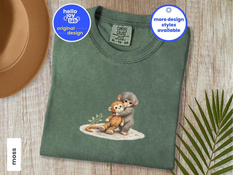 Monkey Punch Comfort Colors T-shirt, T-shirt met babyaapje dat een knuffel vasthoudt, cadeau voor dierenliefhebbers, virale meme van een verdrietig aapje, grafisch T-shirt voor mama en kind. Moss