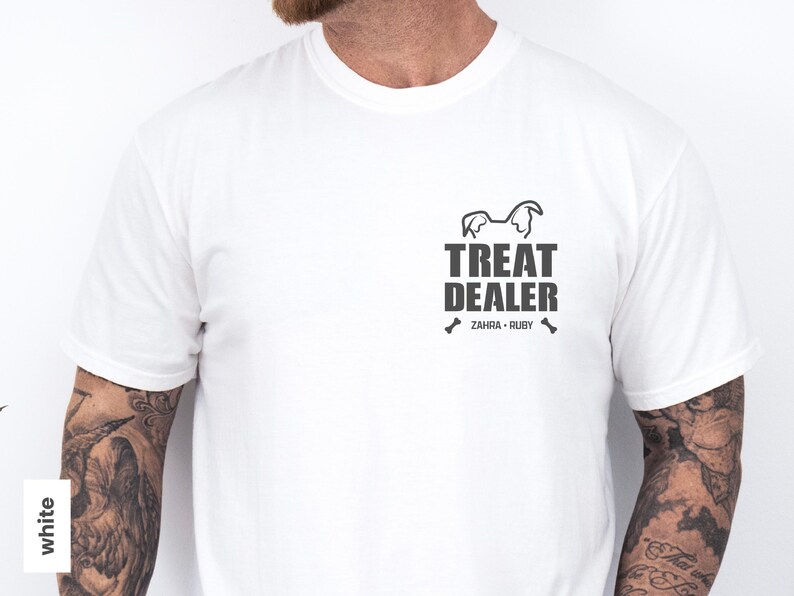 K&ouml;nnte beinhalten: Wei&szlig;es T-Shirt mit schwarzem Aufdruck. Der Aufdruck zeigt den Text "TREAT DEALER", eine Hunde-Silhouette und die Namen "ZAHRA &bull; RUBY". Das T-Shirt hat einen Rundhalsausschnitt.