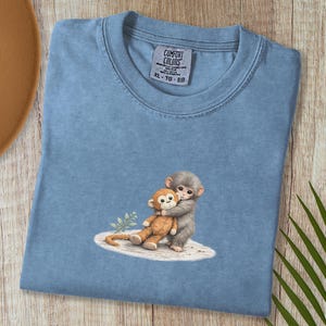 Monkey Punch Comfort Colors T-shirt, T-shirt met babyaapje dat een knuffel vasthoudt, cadeau voor dierenliefhebbers, virale meme van een verdrietig aapje, grafisch T-shirt voor mama en kind. Blue Jean