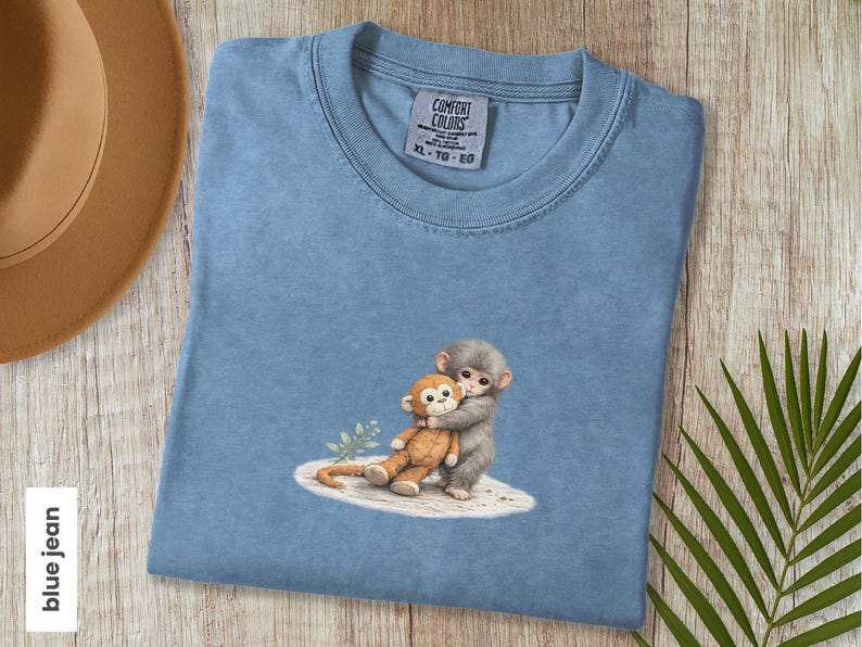 Monkey Punch Comfort Colors T-shirt, T-shirt met babyaapje dat een knuffel vasthoudt, cadeau voor dierenliefhebbers, virale meme van een verdrietig aapje, grafisch T-shirt voor mama en kind. Blue Jean