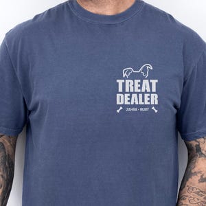 K&ouml;nnte beinhalten: Denimblaues T-Shirt mit wei&szlig;em Aufdruck "TREAT DEALER", einer Hunde-Silhouette und den Namen "ZAHRA &bull; RUBY". Das Shirt hat kurze &Auml;rmel und einen Rundhalsausschnitt.