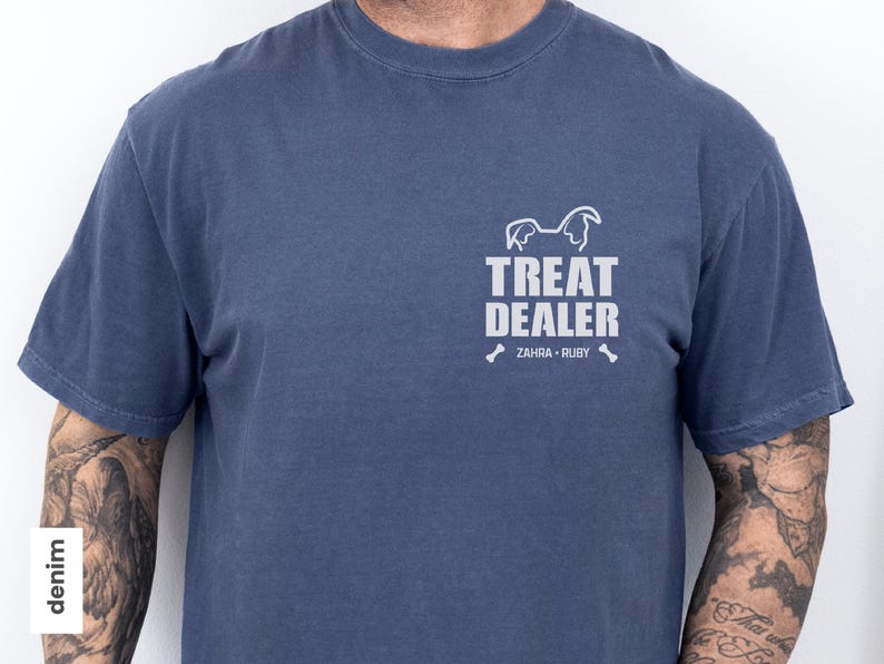 K&ouml;nnte beinhalten: Denimblaues T-Shirt mit wei&szlig;em Aufdruck "TREAT DEALER", einer Hunde-Silhouette und den Namen "ZAHRA &bull; RUBY". Das Shirt hat kurze &Auml;rmel und einen Rundhalsausschnitt.