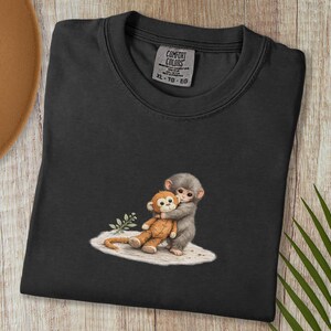 Monkey Punch Comfort Colors T-shirt, T-shirt met babyaapje dat een knuffel vasthoudt, cadeau voor dierenliefhebbers, virale meme van een verdrietig aapje, grafisch T-shirt voor mama en kind. Black