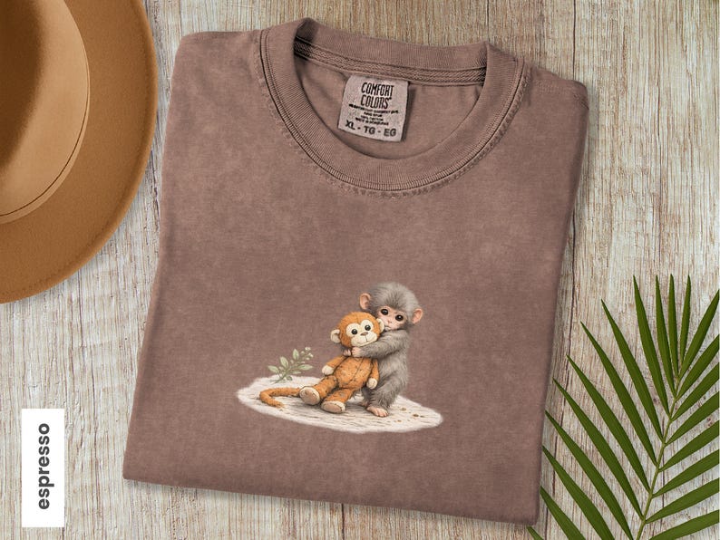 Monkey Punch Comfort Colors T-shirt, T-shirt met babyaapje dat een knuffel vasthoudt, cadeau voor dierenliefhebbers, virale meme van een verdrietig aapje, grafisch T-shirt voor mama en kind. Espresso
