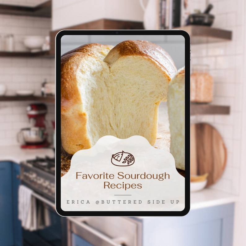 May include: A digital tablet displaying a recipe book cover titled Favorite Sourdough Recipes by Erica @Buttered Side Up. The screen features a high-resolution photograph of a golden-brown loaf of sourdough bread with a soft, airy interior.